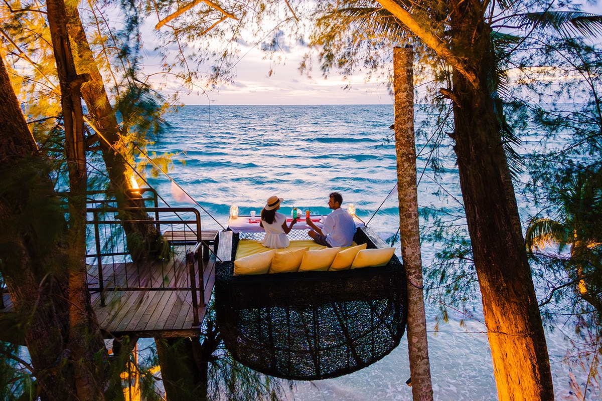 A couple enjoys a romantic, exclusive dining experience provided by their travel loyalty program in Koh Kood, Thailand.