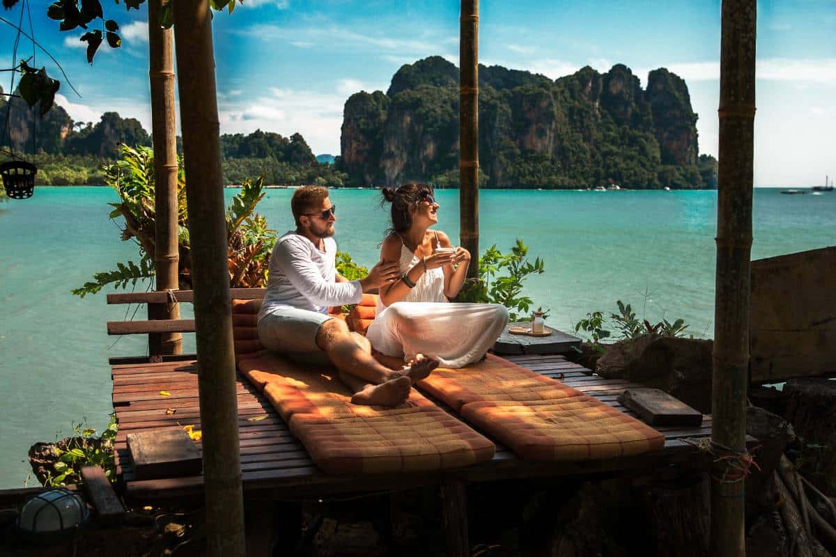 A couple relaxing on a tropical deck during their honeymoon, enjoying a serene and picturesque destination chosen through thoughtful decision-making.