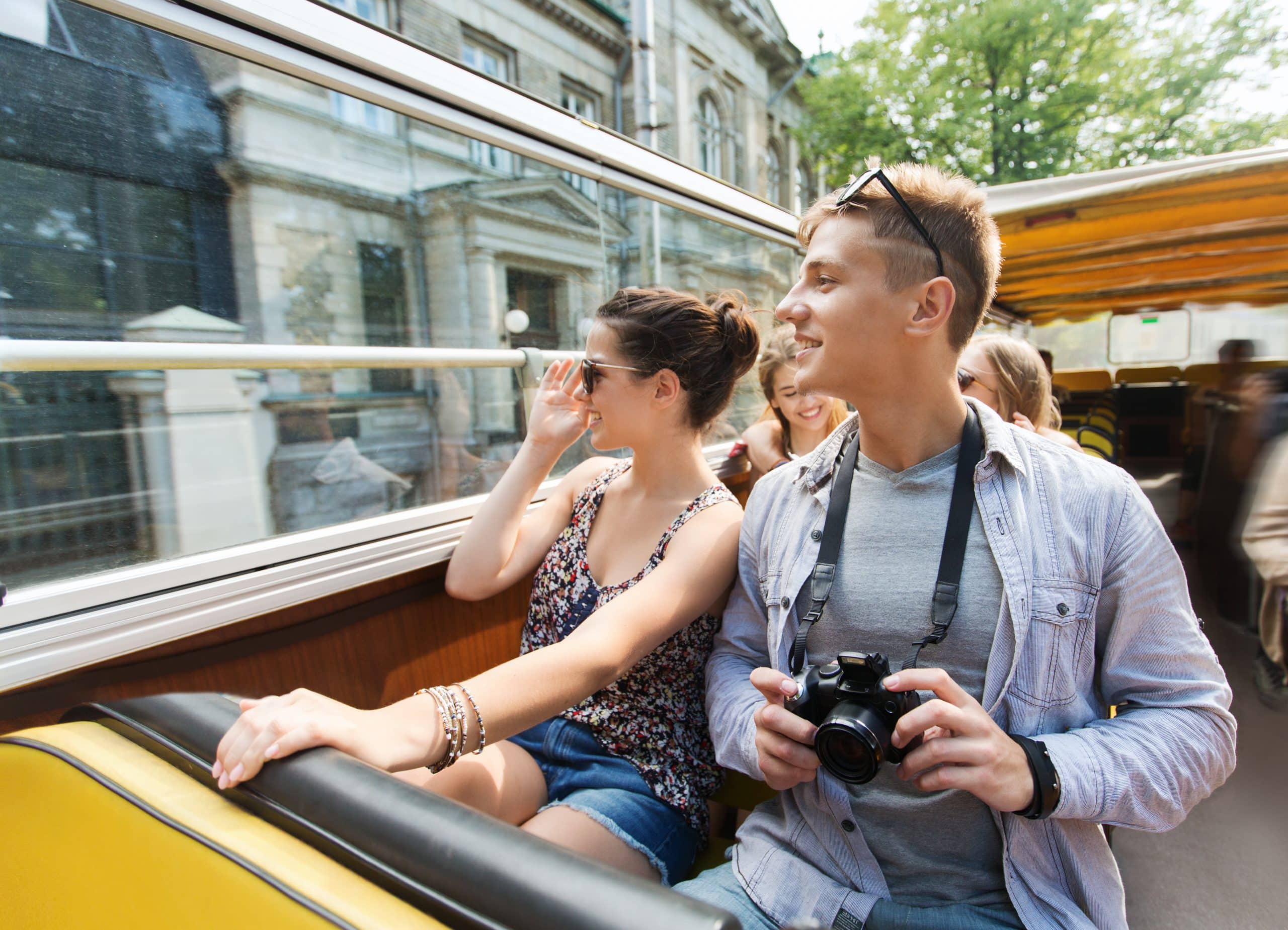 Sightseeing tourists smiling on a bus, showcasing the benefits of AI-powered travel itineraries tailored to member preferences for customized experiences.