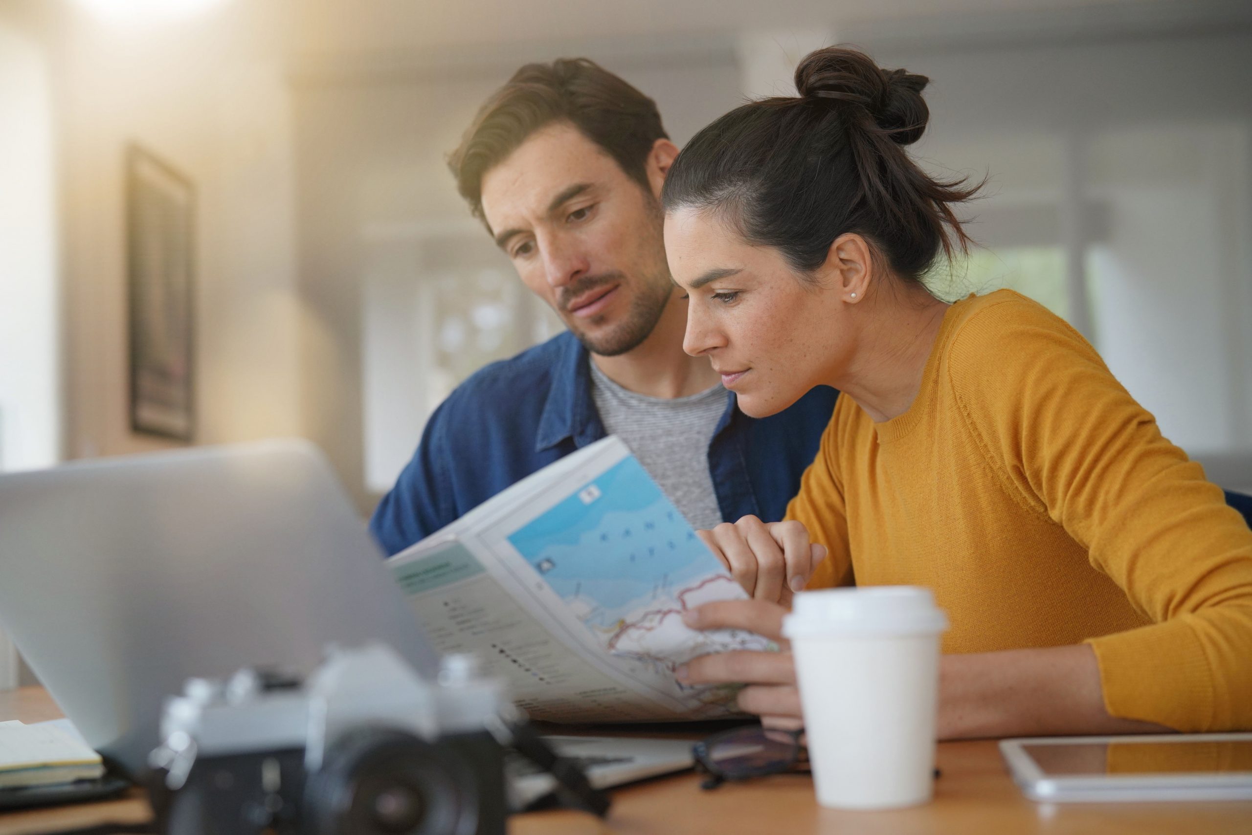 A couple intensely focused on travel planning, with AI-powered tools guiding their next adventure.