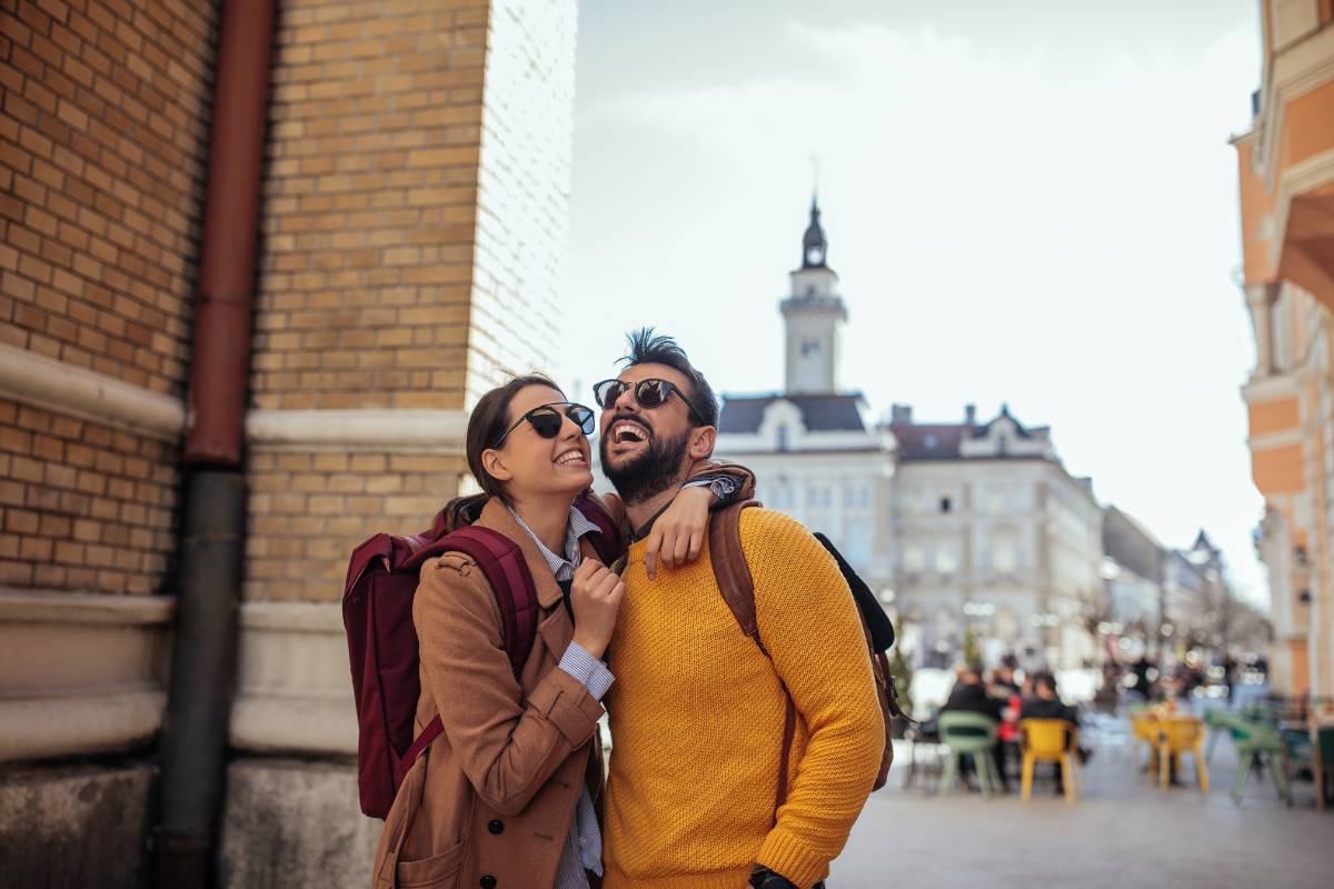 A smiling couple exploring a charming city, enjoying the benefits of personalized travel rewards tailored to their journey.