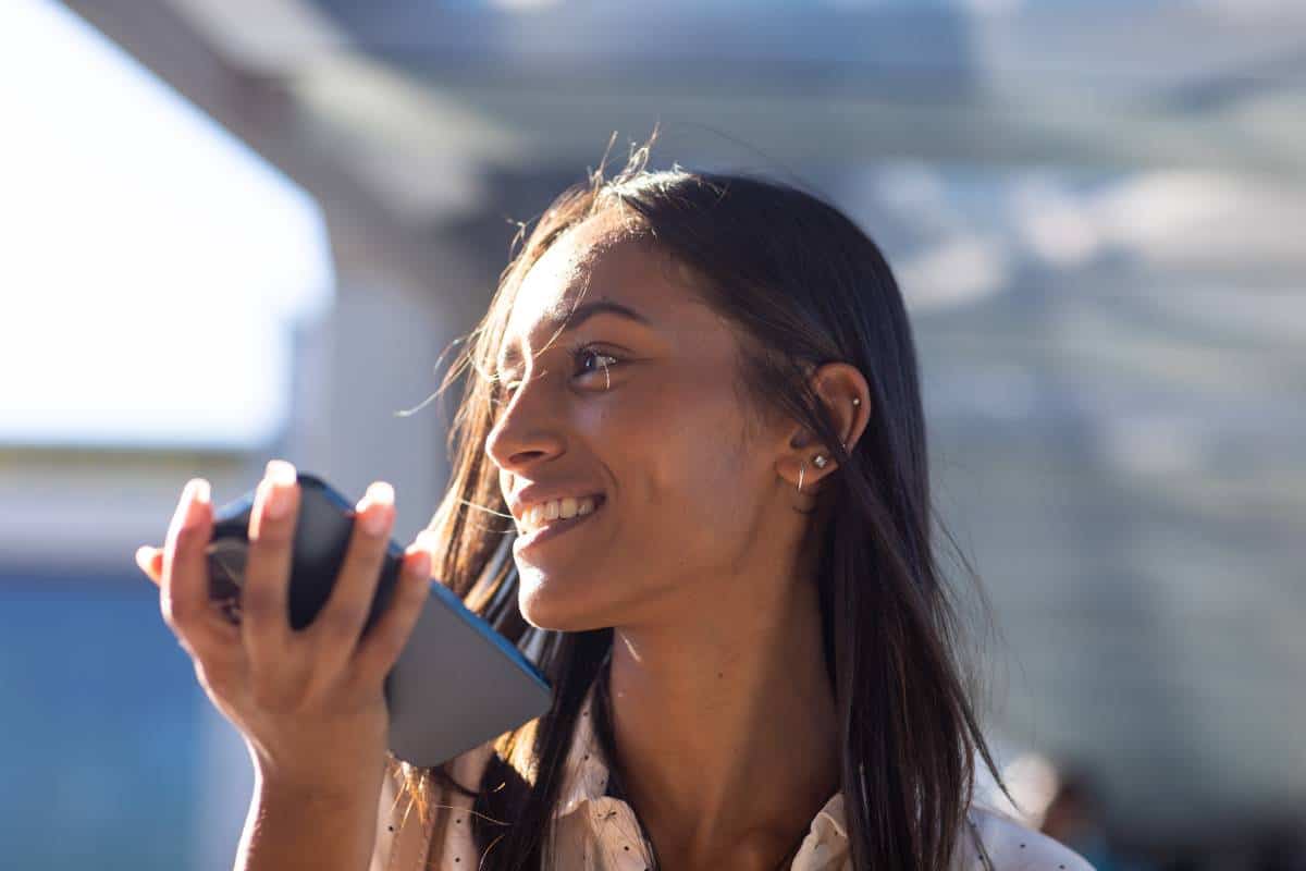 Seamless travel planning in action: A woman utilizes voice booking AI to simplify her journey.